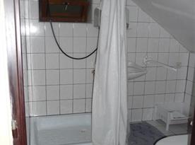 Sociální zařízení v podkroví s toaletou a sprchovým koutem