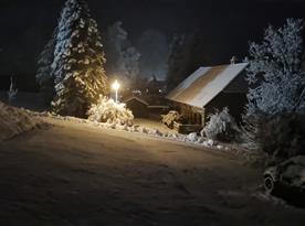 Zimní noční pohled z okna k příjezdové cestě před dům