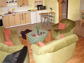 Obývací pokoj se sedací soupravou a televizí
