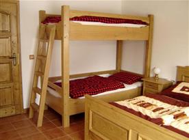 Ložnice v přízemí s manželskou postelí a palandou