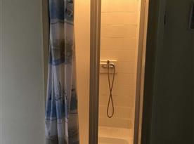 Sprchový kout přístupný z chodby